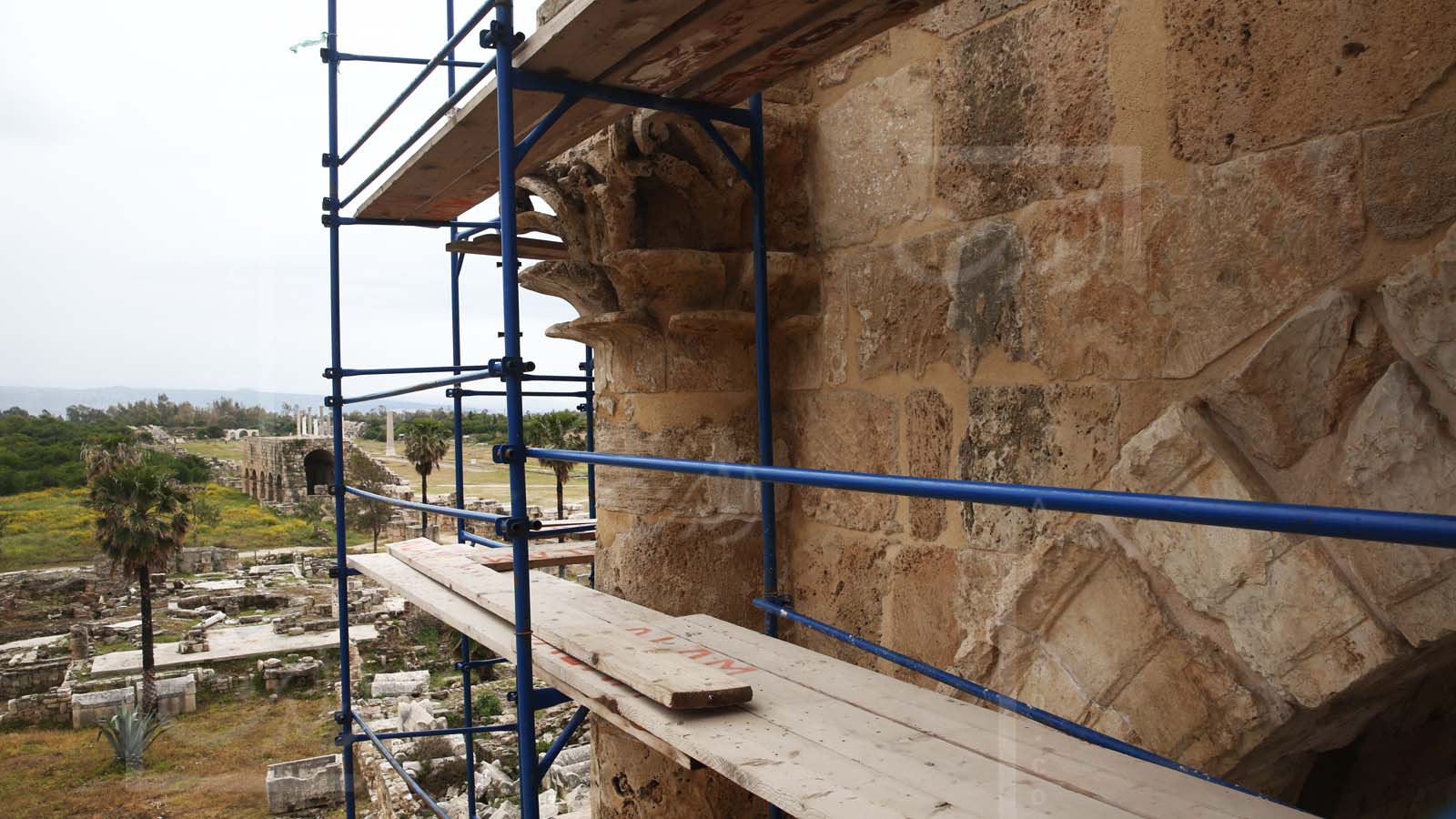 أعمال ترميم قوس النصر في مدخل المدينة الرومانية القديمة. ويظهر ميدان سباق الخيل خلفه (علي علوش)