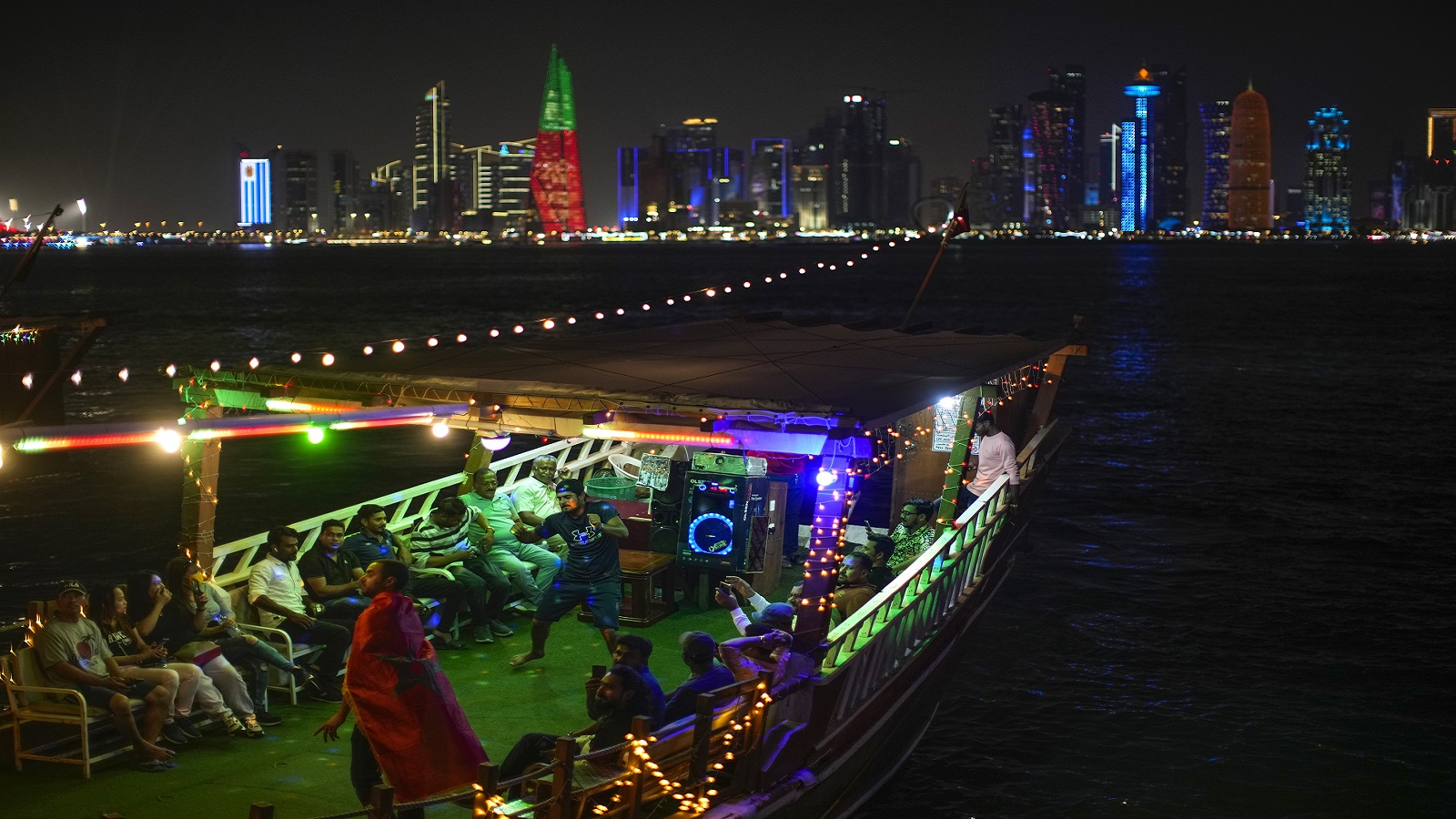 أشخاص يرقصون على قارب في الدوحة (AP)