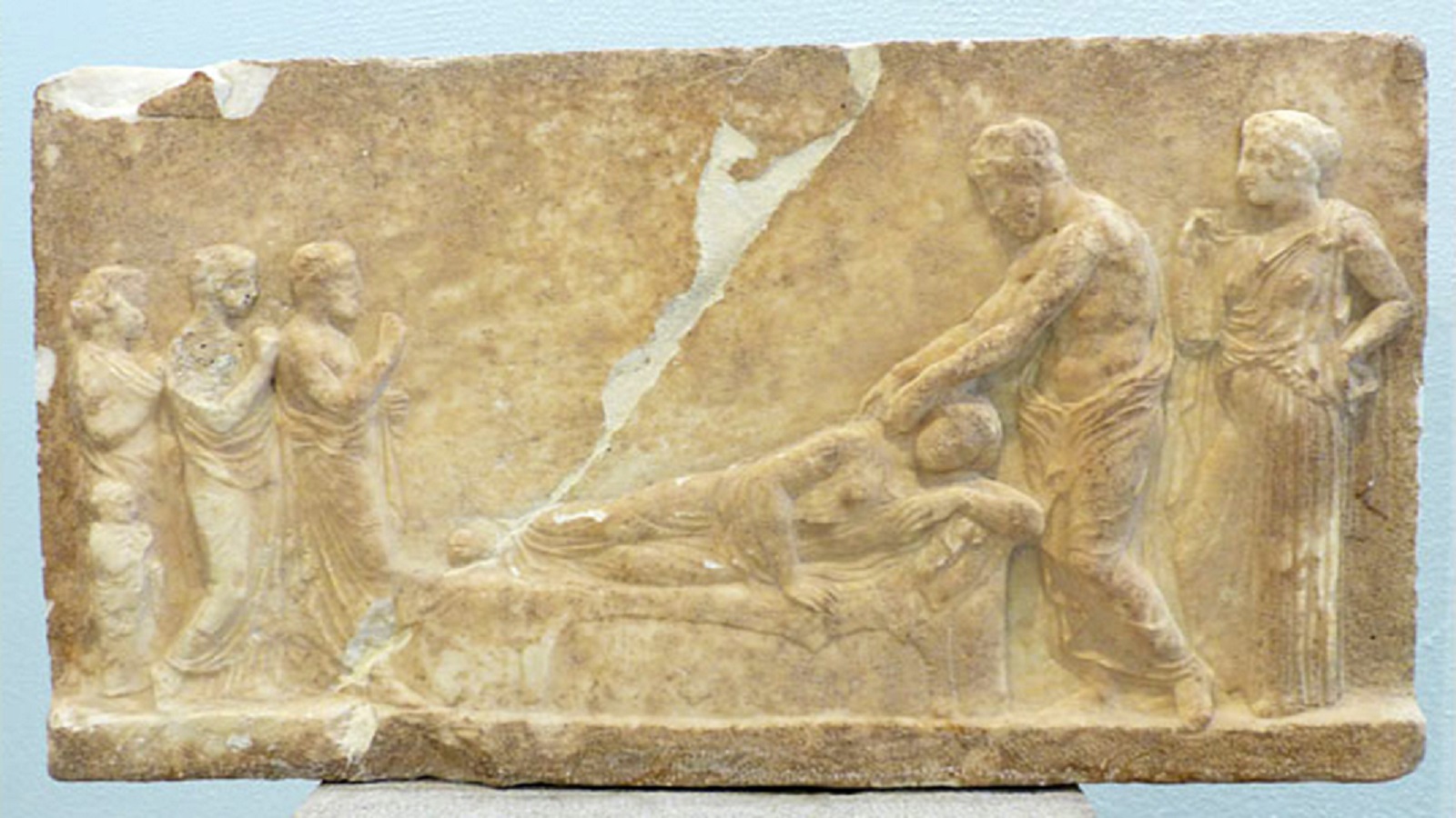 اسقليبيوس وهو يعالج امرأة مريضة بحضور ابنته هيجيا، القرن الرابع قبل الميلاد، متحف بيرايوس