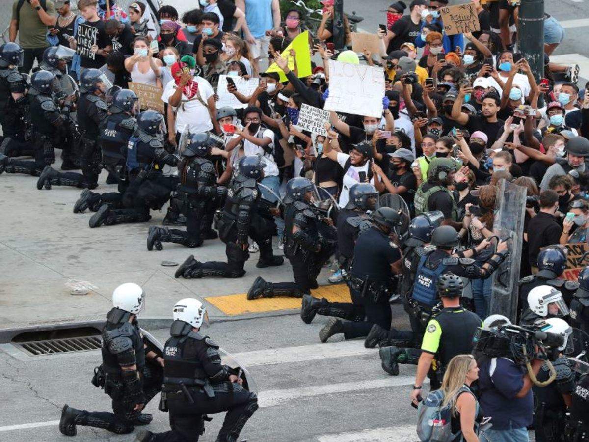 Как в сша называют забастовку полицейских. Полицейские на коленях в США. Толпа протестующих.